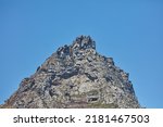 Low angle of a mountain peak isolated against a clear blue sky in South Africa for copy space background. Scenic and quiet mountaintop and rocky landscape view of a remote location on a sunny day