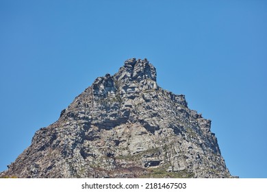 Low angle of a mountain peak isolated against a clear blue sky in South Africa for copy space background. Scenic and quiet mountaintop and rocky landscape view of a remote location on a sunny day