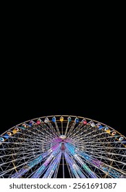 Low angle partial view from below of a Ferris wheel illuminated with colored lights against a dark night sky.