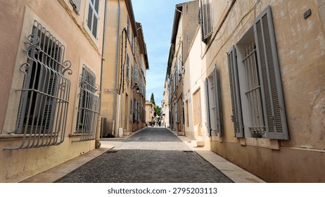 A low angle perspective of a charming narrow alleyway lined with traditional Mediterranean architecture.