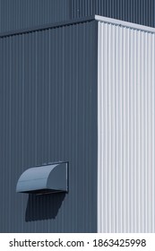 Low angle and perspective view of dryer vent on white and grey corrugated metal warehouse building in vertical frame