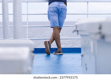 Low angle photo of a caucasian man with short jeans and sneakers on a blue floor