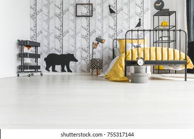 Low Angle Photo Of Kid's Room With Handmade Lamp And Yellow Bedding On Metal Bed