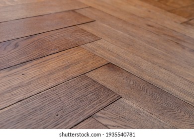 Low Angle Photo Of Orange Brown Aged Old Hundred Year Old Hardwood Oak Parquet Tile Floor Of Herringbone (fish Tale) Flooring