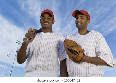 Low angle portrait of baseball team mates against cloudy sky