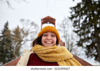 Low Angle Portrait Of Excited Young Woman Sledding Downhill In Winter