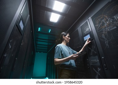 Low Angle Portrait Of Military Woman Using Control Panel While Setting Up Servers In Data Center, Copy Space