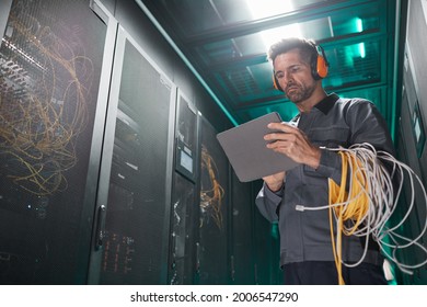 Low angle portrait of network engineer using tablet in server room during maintenance work in data center, copy space