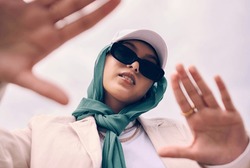 Low Angle Portrait, Woman And City For Muslim Fashion With Gen Z Aesthetic, Streetwear And Sky Background. Young Islamic Girl, Student And Clothes With Sunglasses, Freedom And Outdoor Travel In Dubai