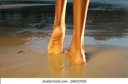 Low angle rear view of an african american woman waling on the beach