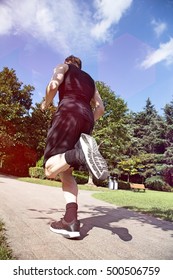 Low Angle Rear View Of Caucasian Man Running In Park