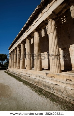Low angle row of fluted Doric marble columns at an ancient Greek temple.