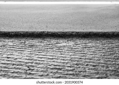 low angle selective focus on asphalt overlay paving on top of a concrete base of a residential street