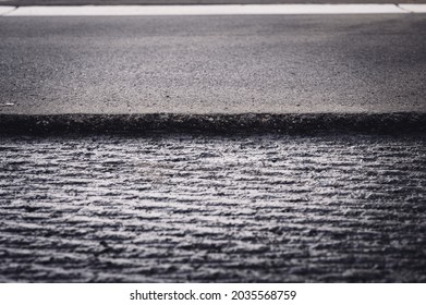 Low Angle Selective Focus On Asphalt Overlay Paving On Top Of A Concrete Base Of A Residential Street