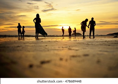 Low angle and selective focus shot of silhouettes of beach goers enjoying the sunset at Tanjung Aru beach, Kota Kinabalu, Sabah. 