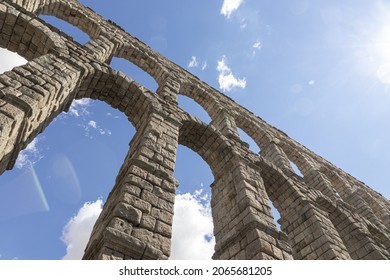 A low angle shot of the Aqueduct of Segovia in Spain, with the sculpture of the Virgin Mary in the Acueducto de Segovia - Powered by Shutterstock