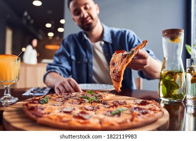 Low Angle Shot Attractive Man With Beard Eating Pizza At Cafe