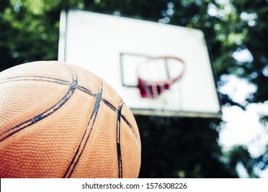 A Low Angle Shot Of A Basketball On A Basketball Court With The Hoop In The Background