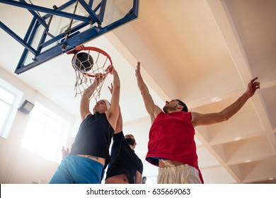 Low Angle Shot Of Basketball Players Playing Basketball On The Court.