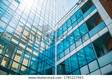 A low angle shot of a business building with glass walls under the sunlight