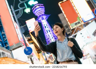 Low Angle Shot Cheerful Asian Woman Sightseer Raising Cellphone And Taking Selfie Picture With  Tower 