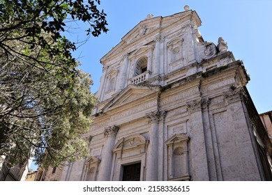 A low angle shot of the Church of Saint Philip Neri in Perugia, Italy with a tree against a blue sky