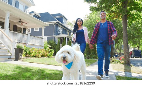 Low Angle Shot Of Couple Walking Dog Along Suburban Street - Powered by Shutterstock