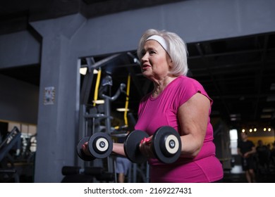 Low Angle Shot Of An Elderly Woman Doing Bicep Curls With Dumbbells