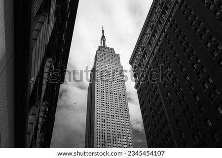 A low angle shot of the Empire State building of New York City, USA in grayscale