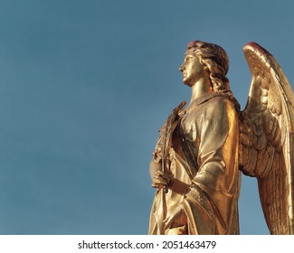 A Low Angle Shot Of A Gold Angel Statue Holding A Feather In Zagreb, Croatia