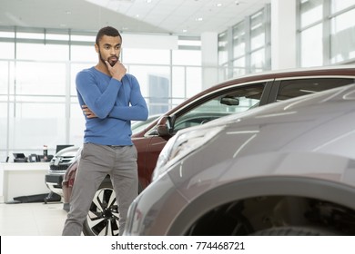 Low Angle Shot Of A Handsome African Man Choosing A New Car At The Dealership Rubbing His Chin Thoughtfully Thinking Copyspace Buying Buyer Choice Decision Consumerism Lifestyle Sale Discount Price