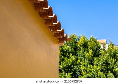 A Low Angle Shot Of A Light Brown Stone Building With Circular Rooftop Tiles