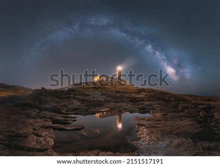 a low angle shot of lighthouse under night sky