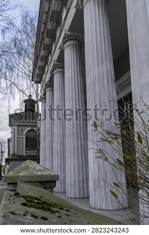 Low angle shot looking up along the towering neoclassical columns of the former Evangelical-Augsburg church portico on Podrzeczna street in Lowicz Poland.