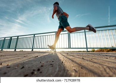 Low Angle Shot Of A Man Running Outdoors.