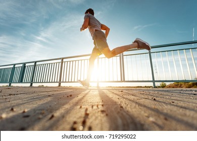 Low Angle Shot Of A Man Running Outdoors.