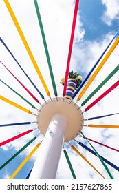 A low angle shot of a Maypole with colorful strings at Countryfile Live, Oxfordshire