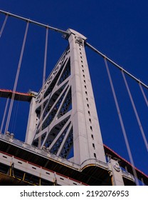 A Low Angle Shot Of A Modern Bridge Against A Blue Sky In Vertical