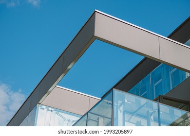 A Low Angle Shot Of A Modern Business Building With Sleek Architecture Under A Bright Blue Sky