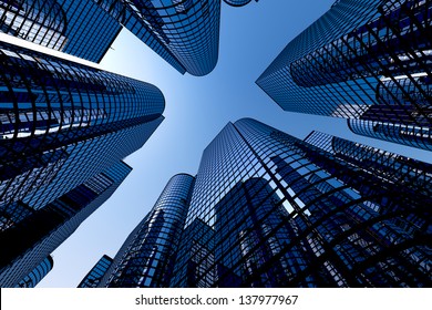 Low angle shot of modern glass city buildings with clear sky background.