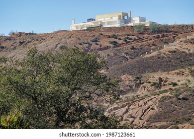 A Low Angle Shot Of A Modern Villa On Top Of A Hill Captured On A Sunny Day