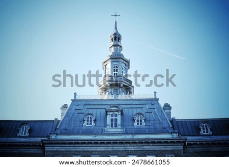 A low angle shot of old Quebec Seminary tower of in Montreal, Quebec, Canada under blue sky