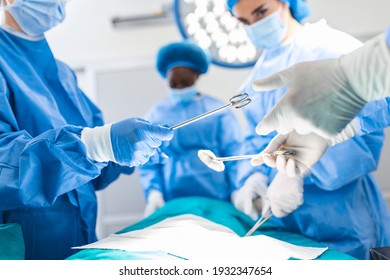 Low Angle Shot in the Operating Room, Assistant Hands out Instruments to Surgeons During Operation. Surgeons Perform Operation. Professional Medical Doctors Performing Surgery. - Shutterstock ID 1932347654