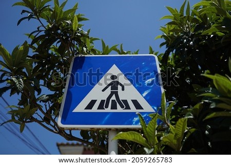 A low angle shot of a pedestrian crossing sign