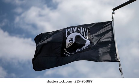 A Low Angle Shot Of The POW MIA Flag Waving On A Pole