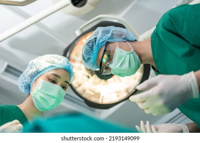 Low Angle Shot Of Professional Surgeons Team Performing Surgery In Operating Room, Surgeon, Assistants, And Nurses Performing Surgery On A Patient, Health Care Cancer And Disease Treatment Concept