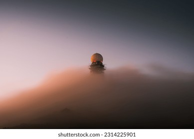 A low angle shot of a radar tower with dense clouds - Powered by Shutterstock