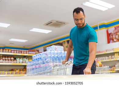 Low Angle Shot Of Smiling African American Man Opening Freezer. Handsome Bearded Guy In Eyeglasses Shopping In Grocery Store. Shopping Concept