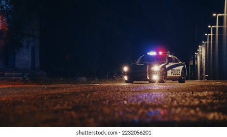 Low Angle Shot of a Stopped Police Car with Lights and Siren on During a Misty Night. Patrolling Vehicle on Stand by, Waiting for Orders to Start Pursuing Suspects. Police Enforcement