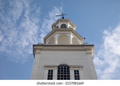 A low angle shot of the top of the Old First Congregational Church in Vermont against blue cloudy sky background